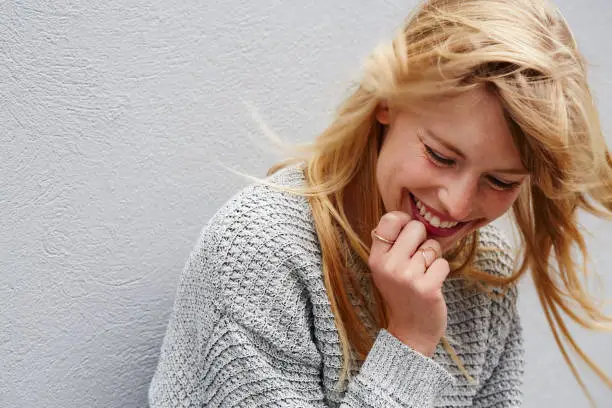 Laughing young blond lady in grey