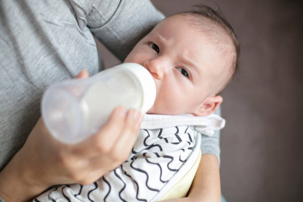 istock Mother holding and feeding newborn baby 878909736