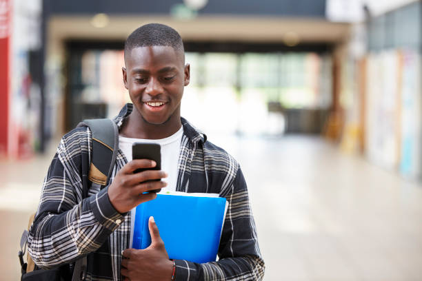 istock Male College Student Reading Text Message On Mobile Phone 878918894