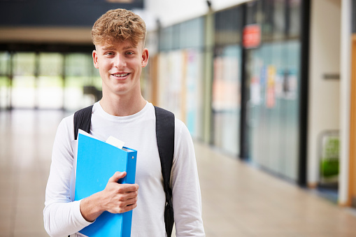 Portrait Of Male Student Standing In College Building