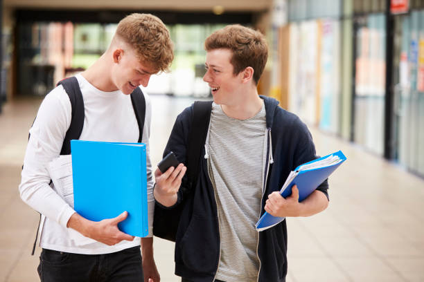 istock Two Male College Students Reading Text Message On Mobile Phone 878918994