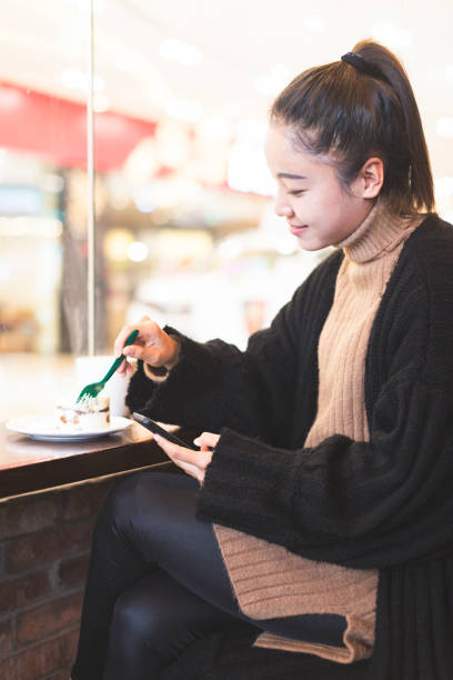 istock woman having a coffee and sweets with cellphone in cafe 878922532