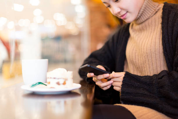 istock woman having a coffee and sweets with cellphone in cafe 878923114