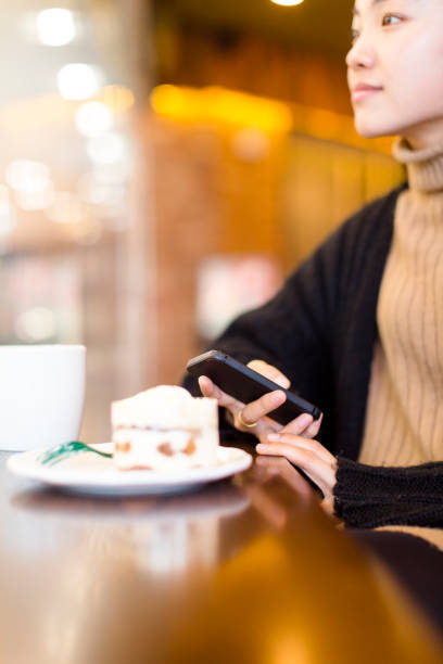 istock woman having a coffee and sweets with cellphone in cafe 878926184