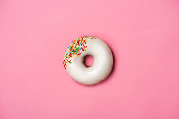 istock Donuts with icing on pastel pink background. Sweet donuts. 878928796