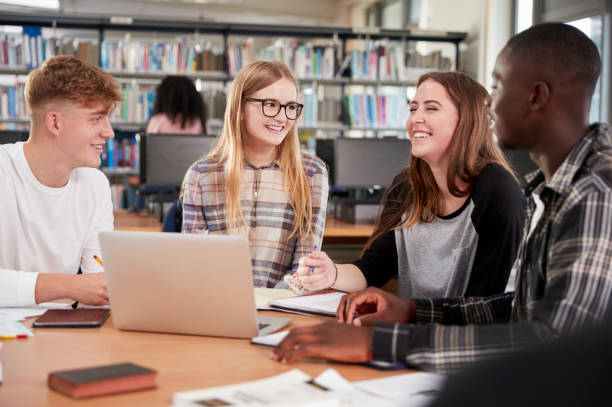 istock Group Of College Students Collaborating On Project In Library 878928834
