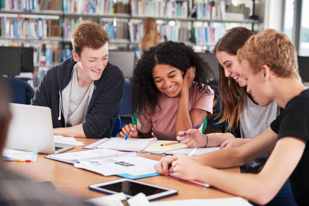 istock Group Of College Students Collaborating On Project In Library 878930962