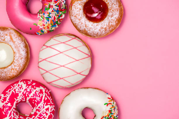 istock Donuts with icing on pastel pink background. Sweet donuts. 878930994