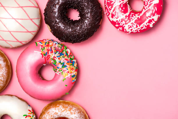 istock Donuts with icing on pastel pink background. Sweet donuts. 878931018
