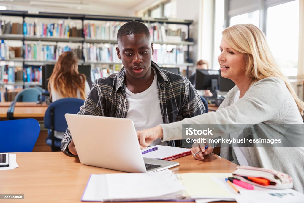 Étudiant au Collège a des cours particuliers de l’enseignant dans la bibliothèque - Photo de Niveau d'éducation libre de droits