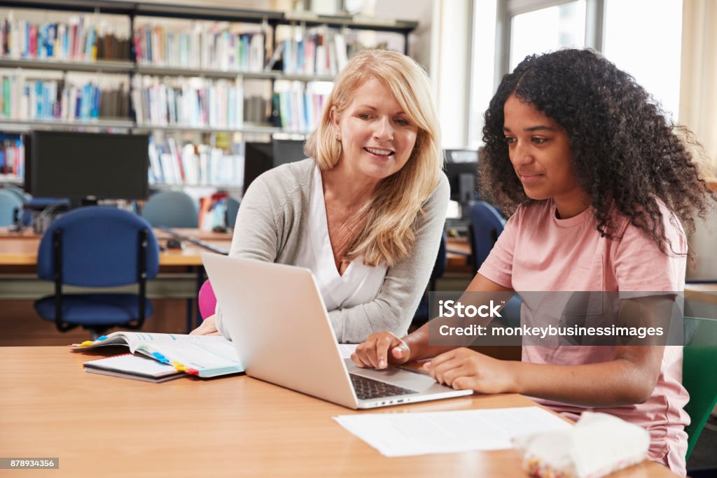 College Student Has Individual Tuition From Teacher In Library Teenager Stock Photo