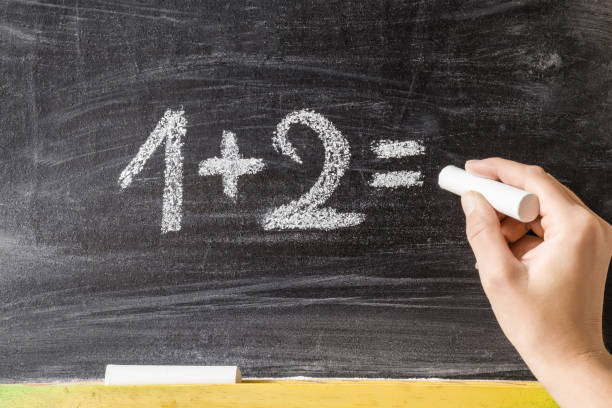 istock Drawn numbers by chalk. Teacher writing and teaching math for little kids on the blackboard. Education concept. 878938302