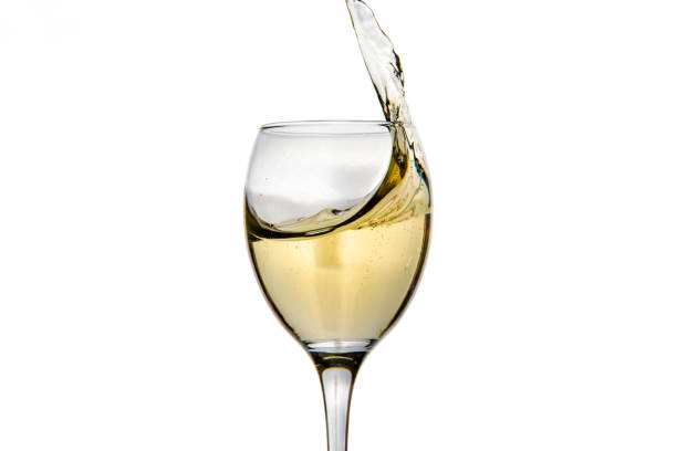 istock Wineglass with splashing drops of champagne 878938434