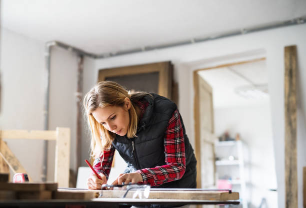 istock Young woman worker in the carpenter workroom. 878962132