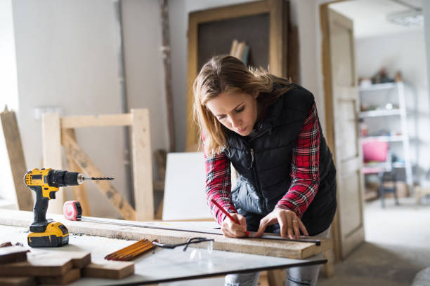 istock Young woman worker in the carpenter workroom. 878964506