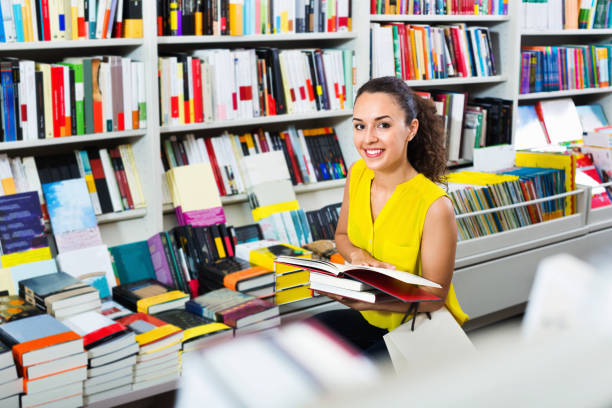 istock Woman standing with open in publishers store 878969690