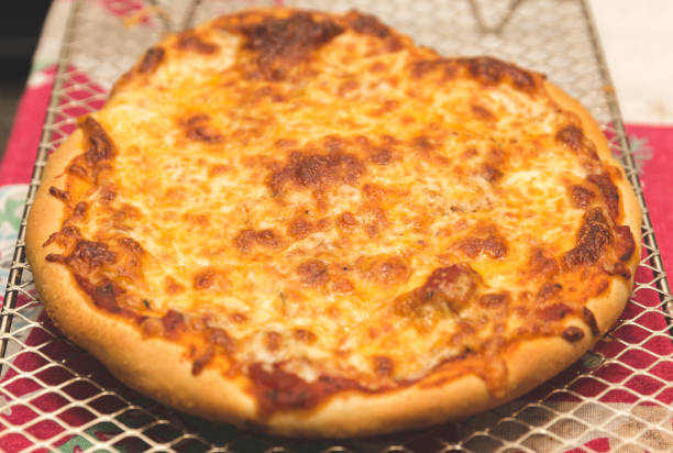 istock Freshly Baked Pizza Cooling on a Metal Rack 878970466