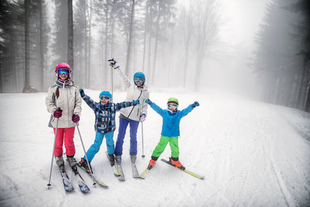 istock Mother skiing with kids on a misty winter day. 878970558