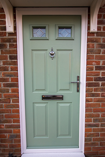 Green door. Modern house composite upvc front door with chrome hardware. Timber look classic design.