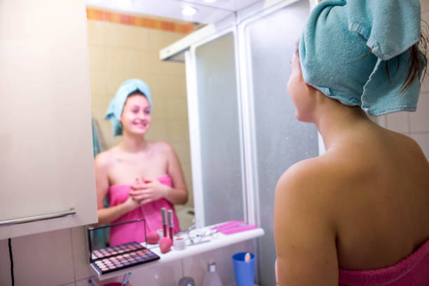 istock Woman looking at herself in the mirror after showering 878973236
