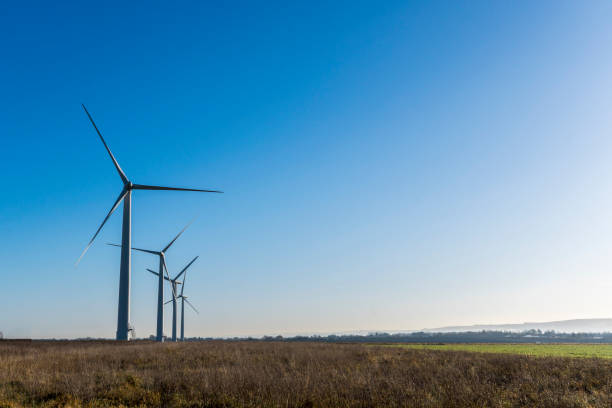 istock Four wind turbines in a field on a bright sunny day 878981110