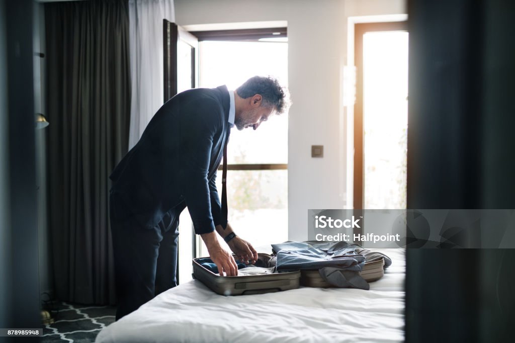 Uomo d'affari maturo in una camera d'albergo. - Foto stock royalty-free di Imballare