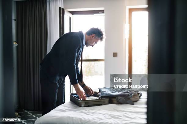 Mature Businessman In A Hotel Room Stock Photo - Download Image Now - Packing, Business Travel, Hotel