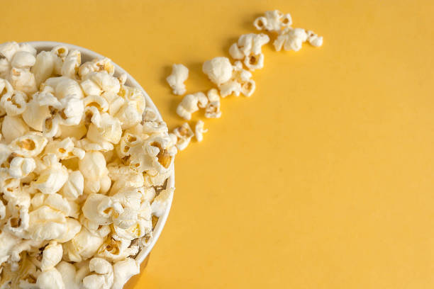 istock Full bucket of popcorn on a yellow background. View from above. 878993688