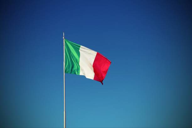 istock Italian flag waving with blue sky with vignette effect 878994012