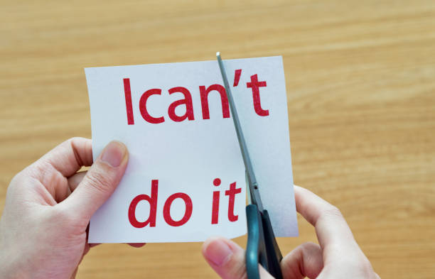 istock Human hand cutting word on paper can't become i can 878994640