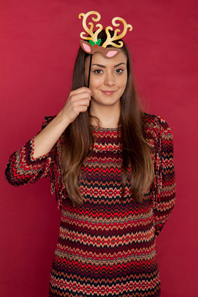istock young beautiful woman puts on reindeer ears 879004798
