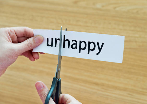 istock Human hand cutting word on paper unhappy become happy 879004972