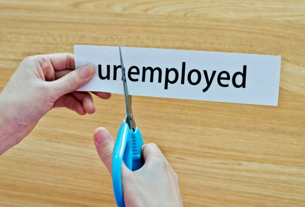 istock Human hand cutting the unemployed word 879005060