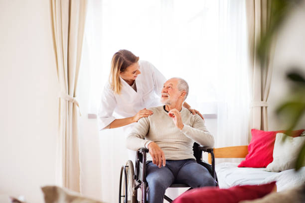 istock Nurse and senior man in wheelchair during home visit. 879005144