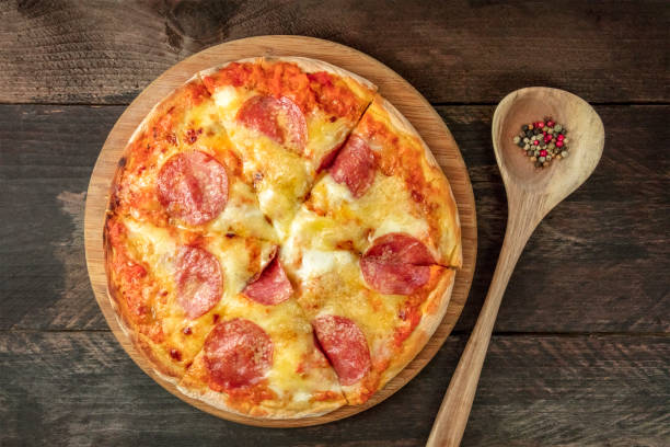 istock Cut pepperoni pizza with peppercorns and copy space 879005658