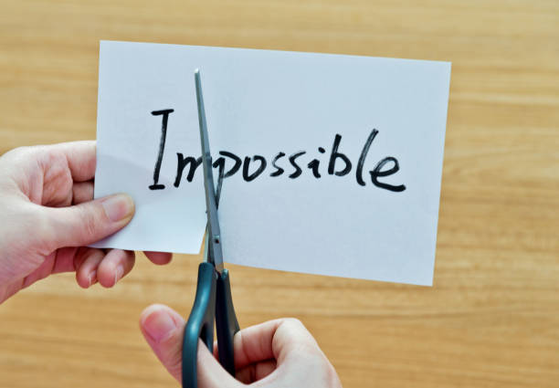 istock Human hand cutting word on paper unknown become possible 879006142
