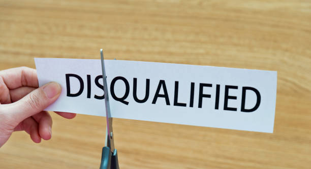 istock Human hand cutting word on paper disqualified become qualified 879007874