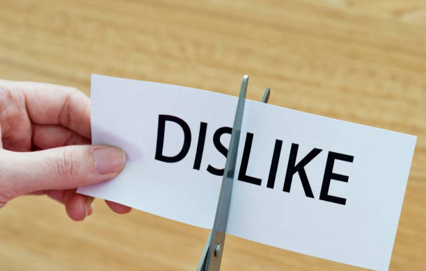 istock Human hand cutting the dislike word 879007936