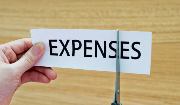 human hand cutting the expenses word - cheap finance cutting downsizing imagens e fotografias de stock
