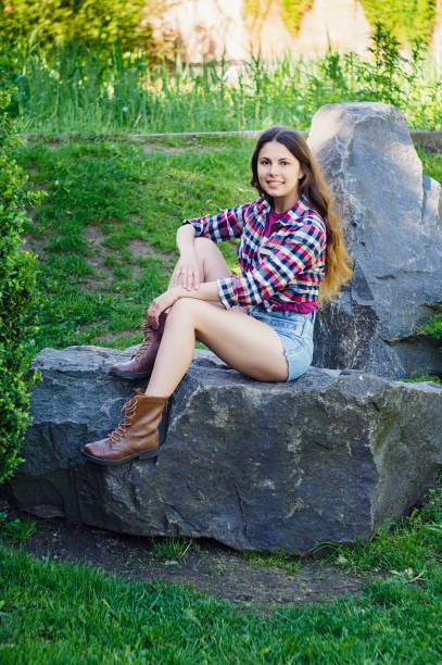 istock Girl on a big stone in the park 879008634