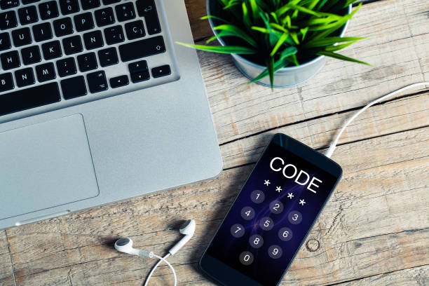 istock Mobile phone placed on a wooden desk with passcode in the screen. 879012020
