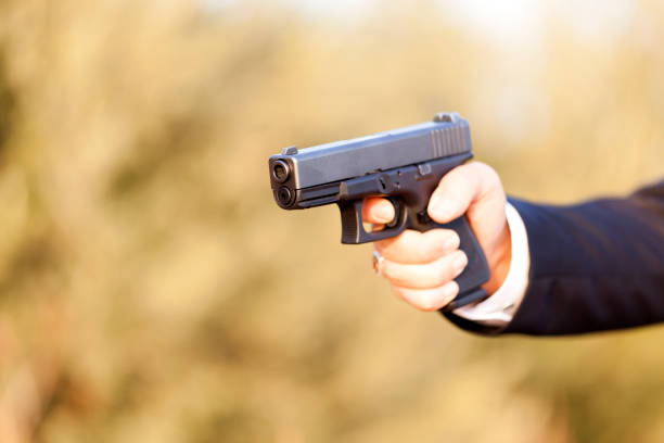 istock Gun with Businessman hand 879015540