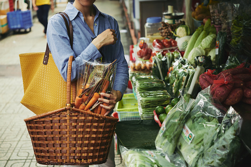 Cropped image of woman buying vegetables at street market