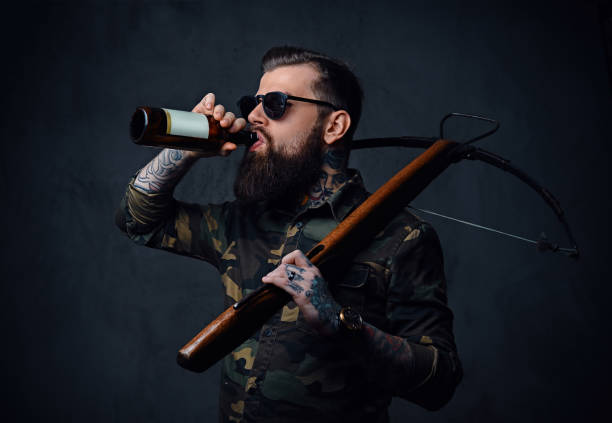 istock A man holds the craft beer bottle and a crossbow. 879024502