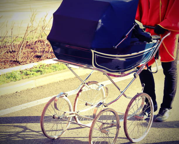 Ancient baby carriage pushed by a person with lomo effect