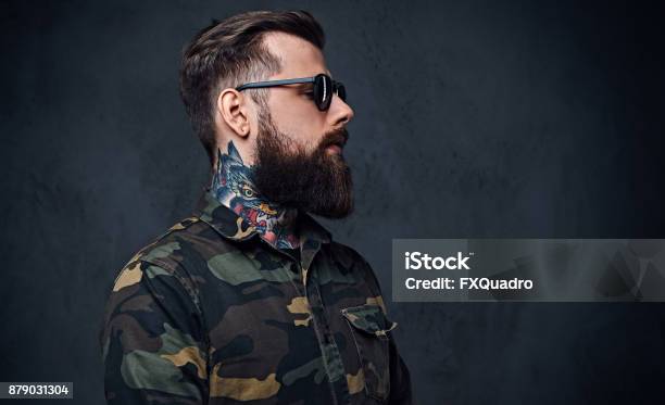 Portrait Of Bearded Tattooed Hipster Male Dressed In A Military Jacket Stock Photo - Download Image Now