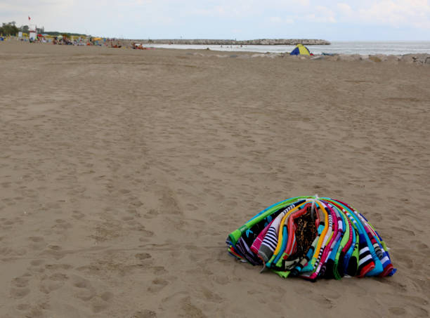 heap of towels abounding on the beach by an abusive seller after - abounding imagens e fotografias de stock