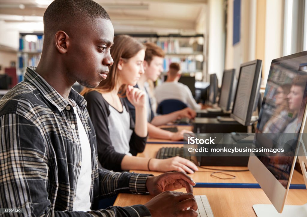 Gruppo di studenti che utilizzano computer nella biblioteca universitaria - Foto stock royalty-free di Tecnologia