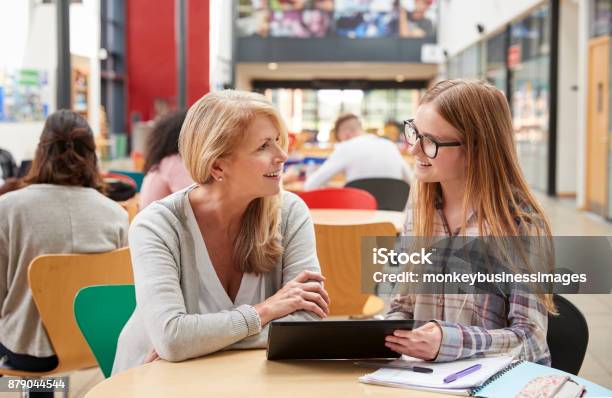 Photo libre de droit de Parle De Professeur À Élève Dans Une Zone Commune De Campus Du Collège banque d'images et plus d'images libres de droit de Enseignant