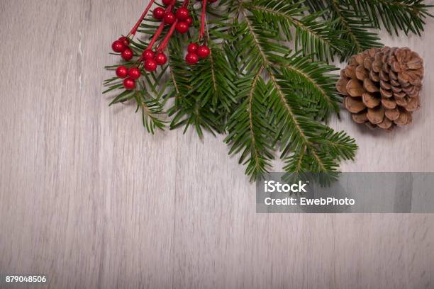 Christmas Holly Pine Tree And Cone Over A Wood Background Stock Photo - Download Image Now